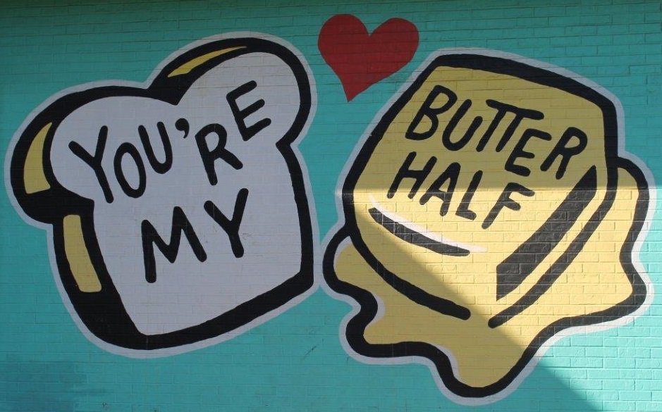 Site image highlighting local art: Graffiti image of a slice of bread and pat of butter. text in graffiti says You're my butter half.