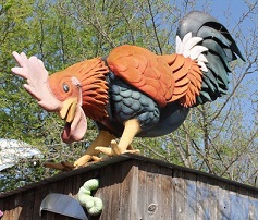 Site image highlighting local art: Sculpted rooster on roof eating worm.